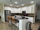 Bright kitchen with white cabinetry, granite countertops, and stainless steel refrigerator and island with seating at 12728 Boggy Pointe Dr, Orlando, FL 32824