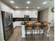 Modern kitchen boasts stainless steel appliances, granite countertops, and a central island with bar stools at 12728 Boggy Pointe Dr, Orlando, FL 32824