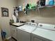 Functional laundry room with sink, cabinets, shelving, washer and dryer at 12728 Boggy Pointe Dr, Orlando, FL 32824