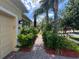 Inviting brick walkway leads to the home, bordered by lush green foliage and mulched flower beds at 12728 Boggy Pointe Dr, Orlando, FL 32824