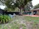 Spacious backyard featuring a large tree, seating area, and a wooden deck, perfect for outdoor entertaining at 1310 Briarwood Ave, Deltona, FL 32725