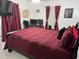 This bedroom features a bed with a red cover and a television at 1310 Briarwood Ave, Deltona, FL 32725