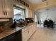 Bright kitchen featuring granite countertops, white cabinetry, and a sink with a view to dining area at 1310 Briarwood Ave, Deltona, FL 32725