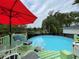 Relaxing above-ground pool and deck area, perfect for enjoying sunny days with comfortable seating and a vibrant red umbrella at 1310 Briarwood Ave, Deltona, FL 32725