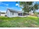 Backyard view highlighting the screened-in porch and grassy yard at 1322 Ravida Woods Dr, Apopka, FL 32703