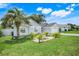Inviting single-story home with a manicured lawn and mature landscaping with beautiful palm trees at 1322 Ravida Woods Dr, Apopka, FL 32703