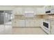 Bright kitchen features white cabinets, stainless appliances, and tile flooring at 1322 Ravida Woods Dr, Apopka, FL 32703