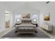 This main bedroom is decorated with a stylish bench, wall art, lamps and two bedside tables at 1322 Ravida Woods Dr, Apopka, FL 32703