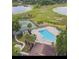 Aerial view of the pool and tennis courts with palm trees near the lake at 1322 Ravida Woods Dr, Apopka, FL 32703
