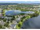Aerial view of a lakeside home surrounded by lush landscaping and neighborhood amenities at 13838 Bluebird Park Rd, Windermere, FL 34786