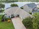 An aerial view of a well-maintained home showing the driveway, landscape and access to a lake at 13838 Bluebird Park Rd, Windermere, FL 34786