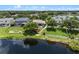 A view of the lush, green backyard extending to the water, enhanced by outdoor seating and mature trees at 13838 Bluebird Park Rd, Windermere, FL 34786