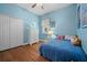 Charming bedroom featuring a blue color scheme, wood floors, and a closet for ample storage at 13838 Bluebird Park Rd, Windermere, FL 34786