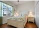 Bright bedroom with wood floors, a large window, and a comfortable queen bed at 13838 Bluebird Park Rd, Windermere, FL 34786
