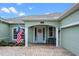 Inviting home entrance with white columns, a beautiful door with a wreath, and a quaint bench at 13838 Bluebird Park Rd, Windermere, FL 34786
