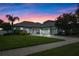 Beautiful home at dusk featuring lush lawn, brick driveway, and charming front facade at 13838 Bluebird Park Rd, Windermere, FL 34786