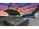 Backyard oasis with screened-in pool, hot tub, lake view, and comfortable seating area at 13838 Bluebird Park Rd, Windermere, FL 34786