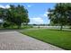 A well-manicured lawn leads to a tranquil lake, showcasing the property's waterfront access at 13838 Bluebird Park Rd, Windermere, FL 34786