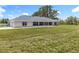 Expansive backyard with a view of the home's rear, highlighting a covered patio ideal for outdoor enjoyment at 14243 County Road 450, Umatilla, FL 32784