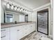 Bathroom vanity with double sinks, granite counters, and a modern shower at 14243 County Road 450, Umatilla, FL 32784