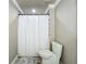 Bathroom featuring a shower with a white shower curtain and light gray tiled floors at 14243 County Road 450, Umatilla, FL 32784