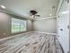 Bright and open bedroom featuring modern ceiling fan, neutral paint, trim, and wood-look tile flooring at 14243 County Road 450, Umatilla, FL 32784