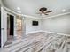 Open concept bedroom with a ceiling fan, TV, and entrance to bathroom at 14243 County Road 450, Umatilla, FL 32784