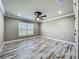 Bedroom featuring wood-look flooring, crown molding, ceiling fan and large window at 14243 County Road 450, Umatilla, FL 32784