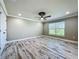 Bedroom with wood-look tile flooring, ceiling fan, crown molding, and a large window at 14243 County Road 450, Umatilla, FL 32784