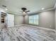 Bedroom featuring a ceiling fan and wood-look tile flooring, plus door leading to the main kitchen/living area at 14243 County Road 450, Umatilla, FL 32784