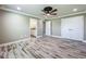 Bedroom with wood-look tile flooring, ceiling fan, and entry to en suite bathroom at 14243 County Road 450, Umatilla, FL 32784
