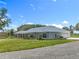 Well-maintained single-story home featuring stone accents and lush landscaping enhancing curb appeal at 14243 County Road 450, Umatilla, FL 32784
