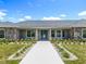 Inviting front entrance with stone accents, manicured lawn, and a long walkway at 14243 County Road 450, Umatilla, FL 32784