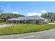 Charming exterior with stone accents, manicured lawn, and attached garage at 14243 County Road 450, Umatilla, FL 32784