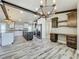 Spacious kitchen with granite countertops, dual islands, dark wood accents, wood look flooring, and built in desk at 14243 County Road 450, Umatilla, FL 32784