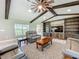 Cozy living room with vaulted ceilings, exposed beams, and a custom built-in entertainment center at 14243 County Road 450, Umatilla, FL 32784