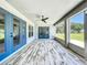 Spacious covered patio boasts a ceiling fan, blue trim, and scenic outdoor views at 14243 County Road 450, Umatilla, FL 32784