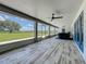 Covered outdoor patio offers tranquil views and features a ceiling fan and tile flooring at 14243 County Road 450, Umatilla, FL 32784