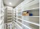 Large walk-in closet features custom white shelving units and wood-look flooring at 14243 County Road 450, Umatilla, FL 32784
