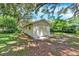 The outbuilding with a concrete pad, features neutral paint, complemented by lush greenery and mossy trees at 1506 S Elliott St, Sanford, FL 32771