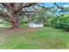 The outbuilding sits on a lush lawn with a large oak tree providing ample shade at 1506 S Elliott St, Sanford, FL 32771