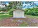 The outbuilding features neutral paint, complemented by lush greenery, and a concrete pad at 1506 S Elliott St, Sanford, FL 32771