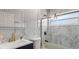 Stylish bathroom featuring marble walls, modern fixtures, glass shower enclosure, and graphic wallpaper at 1614 Oak Hill Trl, Kissimmee, FL 34747