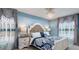 Elegant bedroom featuring a chandelier, striking blue accents, and detailed window treatments for a luxurious feel at 1614 Oak Hill Trl, Kissimmee, FL 34747