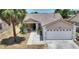 Charming single-story home featuring a two-car garage, covered porch, and lush landscaping at 1614 Oak Hill Trl, Kissimmee, FL 34747