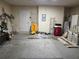 Unfinished garage with bare concrete floors and walls, overhead lighting, and a variety of items at 1797 Tillstream Dr, Orlando, FL 32818