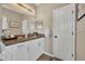 Well-lit bathroom features a spacious vanity with granite countertops, a decorative mirror, and a tiled floor at 183 Longview Ave, Kissimmee, FL 34747