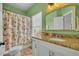 Bright bathroom with peach and green color scheme, decorative mirror, and well-lit vanity at 183 Longview Ave, Kissimmee, FL 34747