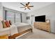 Inviting bedroom with neutral tones, ceiling fan, and an elegant dresser under a large-screen TV at 183 Longview Ave, Kissimmee, FL 34747