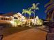 Exterior nighttime view of a beautiful home with lush landscaping and palm trees at 204 Quail Trail Ct, Lake Mary, FL 32746